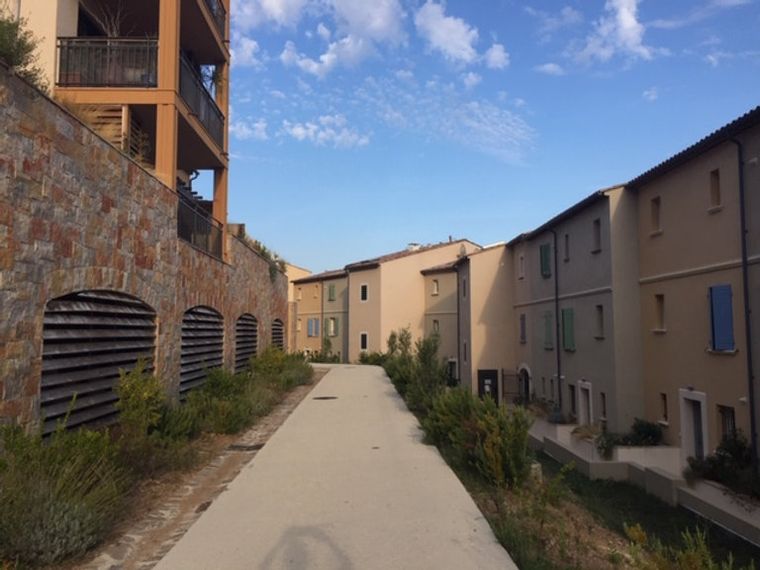 Un éco-hameau : un immeuble et des maisons de village le long d'une allée